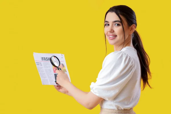 Mujer Joven Con Lupa Leyendo Periódico Sobre Fondo Amarillo — Foto de Stock