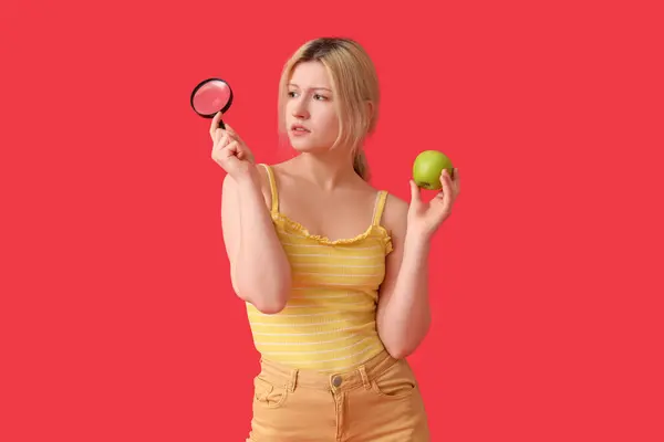 Thoughtful Young Woman Magnifier Apple Red Background — Stock Photo, Image