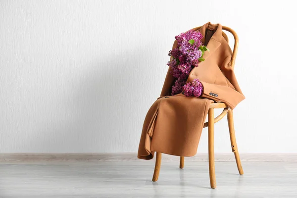 Casaco Feminino Elegante Com Belas Flores Lilás Cadeira Perto Parede — Fotografia de Stock