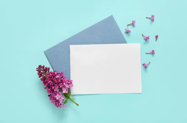 Cartão Branco Com Flores Lilás Sobre Fundo Azul Pálido — Fotografia de Stock