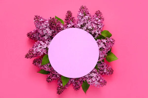 Purple blank card and lilac flowers on pink background