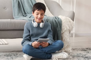 Evde tablet bilgisayar kullanan küçük bir çocuk.