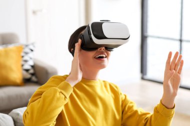 Pretty young woman in VR glasses at home