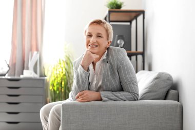 Ofisteki koltukta oturan olgun iş kadını.