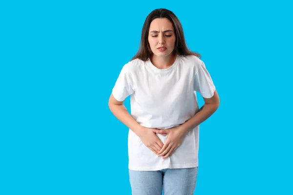 Young Woman Suffering Menstrual Cramps Blue Background — Foto Stock