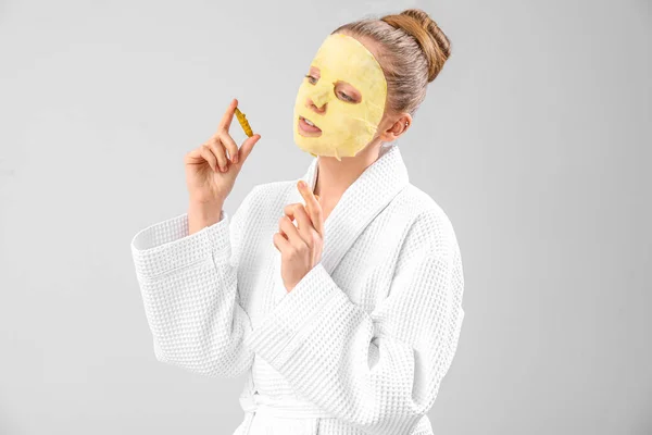 Young Woman Bathrobe Turmeric Sheet Mask Roots Grey Background —  Fotos de Stock