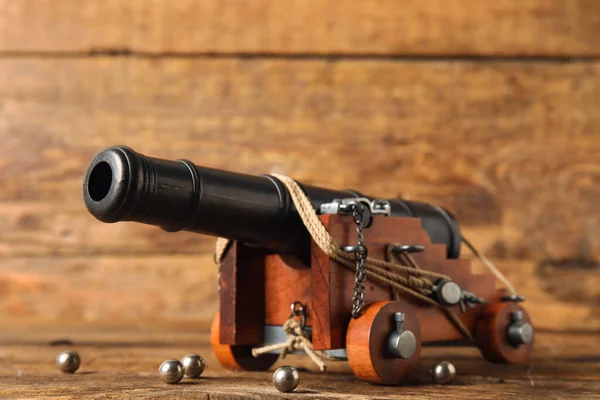 stock image Toy model of cannon on wooden background