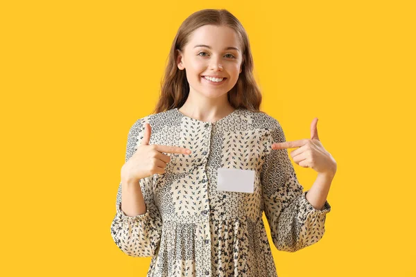 Prodávající Žena Ukazuje Svůj Odznak Žlutém Pozadí — Stock fotografie