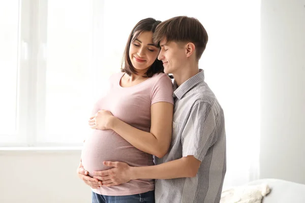 Young Pregnant Couple Hugging Home — Stock Photo, Image