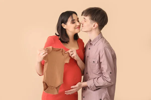 Mladý Těhotný Pár Baby Bodysuit Béžovém Pozadí — Stock fotografie