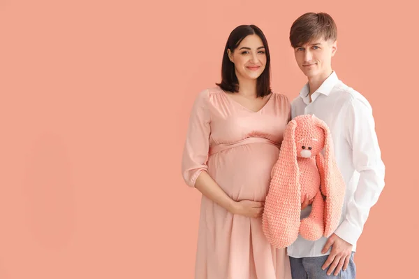 Junge Schwangere Paare Mit Spielzeughasen Auf Rosa Hintergrund — Stockfoto