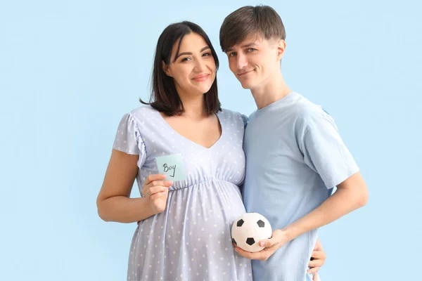 Young Pregnant Couple Holding Paper Word Boy Ball Blue Background — Stock Photo, Image