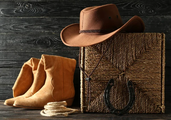 Cowboy boots, hat and horseshoe on wooden background