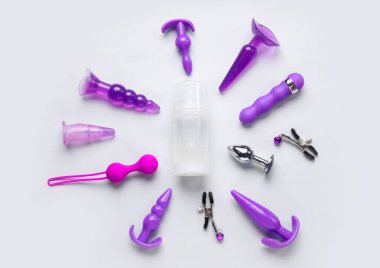 Gri arka planda bir şişe kayganlaştırıcı ve seks oyuncakları