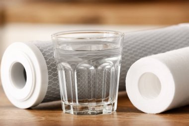 Mutfaktaki ahşap masada filtreli bir bardak su.