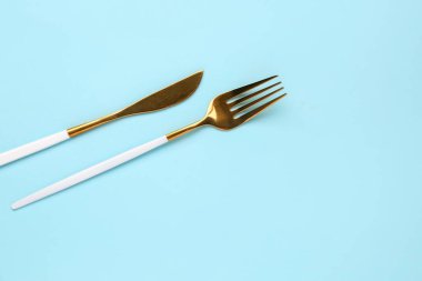 Mavi arka planda paslanmaz çelik çatal ve bıçak
