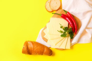 Lezzetli işlenmiş peynirli ekmek ve biberli sarı arka plan.