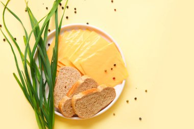 Turuncu arka planda ekmek ve soğanlı lezzetli işlenmiş peynir tabağı.