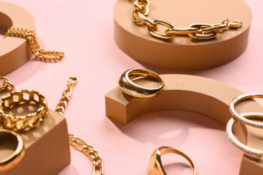 Pembe arka planda güzel mücevherleri olan dekoratif podyumlar.