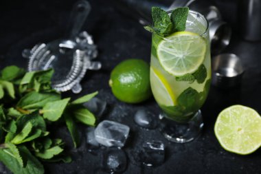 Karanlık arka planda bir bardak soğuk mojito.
