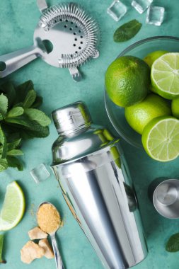 Grunge arkaplanı üzerine mojito hazırlamak için titretici, süzgeç ve malzemeler