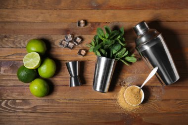Titretici, ölçü kabı ve ahşap zemin üzerinde mojito hazırlamak için malzemeler