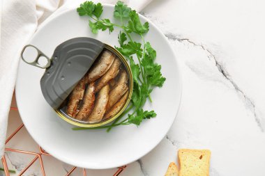 Beyaz arka planda maydanozlu tütsülenmiş sprat tabağı.