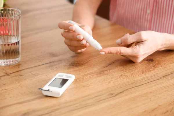 Olgun Diyabetik Kadın Kan Şekeri Seviyesini Ölçüyor Mutfakta Tükenmez Kalemle — Stok fotoğraf