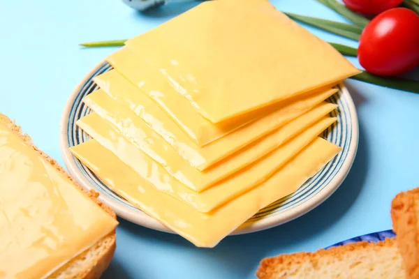 Platen Van Smakelijke Verwerkte Kaas Met Brood Groenten Blauwe Achtergrond — Stockfoto