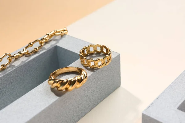 Showcase Pedestais Com Anéis Dourados Pulseiras Sobre Fundo Cor — Fotografia de Stock