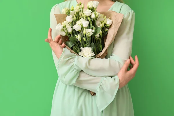 緑の背景に美しい花の花束を持つ若い女性 — ストック写真