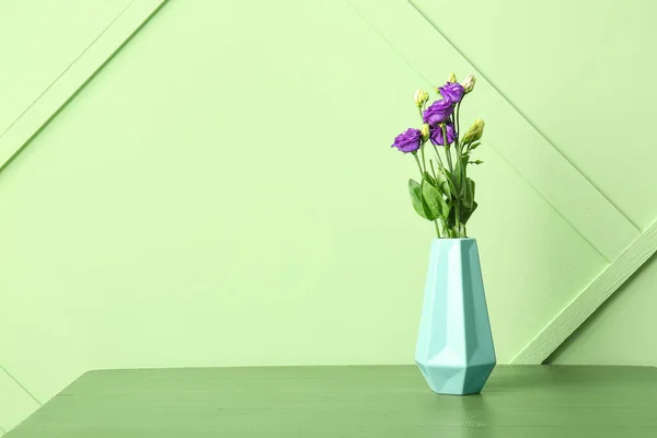 緑の壁の近くのテーブルの上に花のある花瓶 — ストック写真