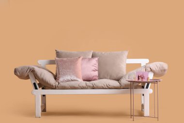 Bej arka planda rahat bir kanepe ve kahve masası.