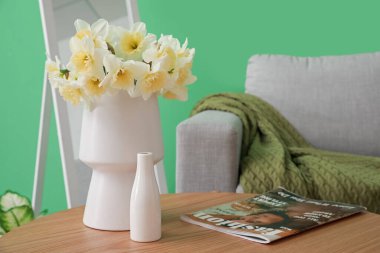 Oturma odasındaki sehpada çiçekli vazo, yakın plan.