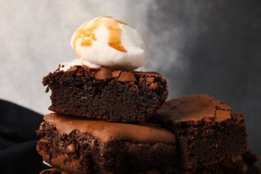 Lezzetli çikolatalı browni parçaları ve grunge arka planda dondurma, yakın plan.