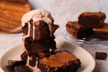 Lezzetli çikolatalı browni ve açık arkaplanda dondurma parçaları.