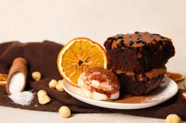 Lezzetli çikolatalı browni ve açık arkaplanda dondurma parçaları.