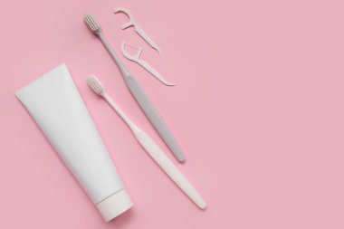Pembe arka planda plastik diş fırçaları, kürdan ve yapıştırıcı.