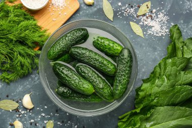 Yeşil arka planda korunması için taze salatalıklı kase.