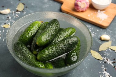 Yeşil arka planda korunması için taze salatalıklı kase.