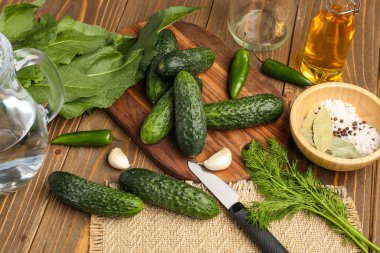 Taze salatalık ve ahşap arka planda korunacak malzemeler.