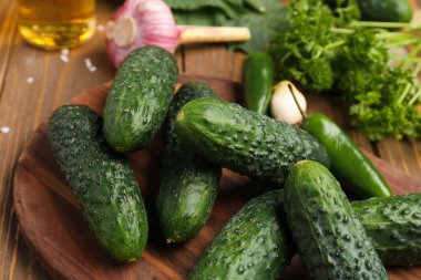 Masada taze salatalıklı ahşap tahta var, yakın plan.