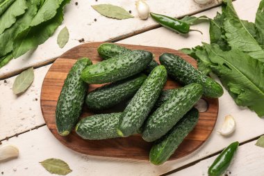 Hafif ahşap arka planda taze salatalık korunması için kurulmuş.