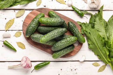 Hafif ahşap arka planda taze salatalık korunması için kurulmuş.