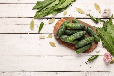 Hafif ahşap arka planda taze salatalık korunması için kurulmuş.