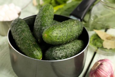 Masada taze salatalıklı tencere, yakın plan.