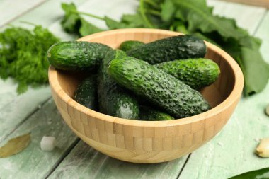 Hafif ahşap arka planda korunması için taze salatalıklı bir kase.