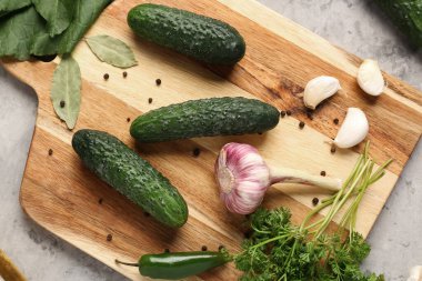 Masada taze salatalık ve sarımsaklı ahşap tahta var.