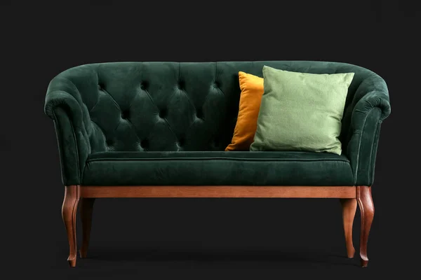 黑色背景的带靠垫的时髦绿色沙发 — 图库照片