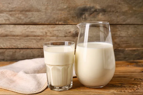 Krug Und Glas Mit Frischer Milch Auf Holzgrund — Stockfoto